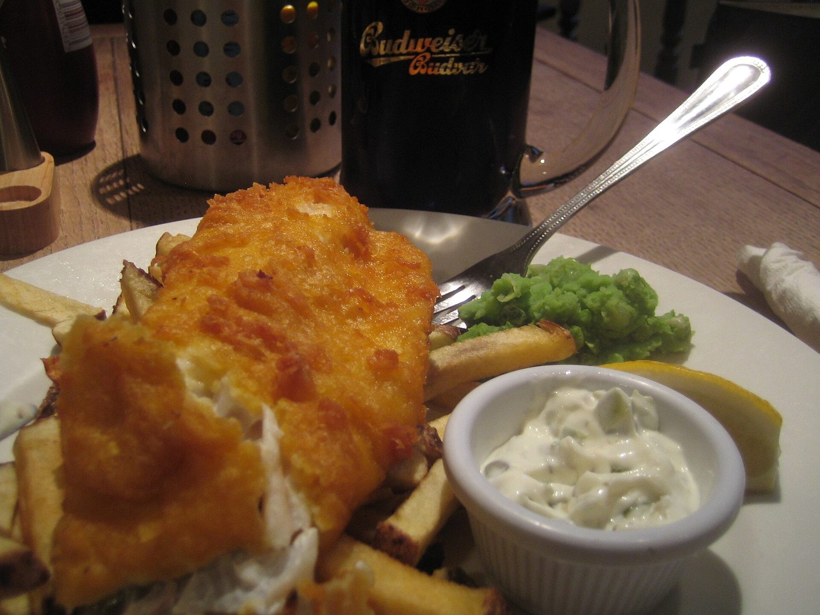 Beer-battered fish and chips with mushy peas, tartare sauce, and lemon