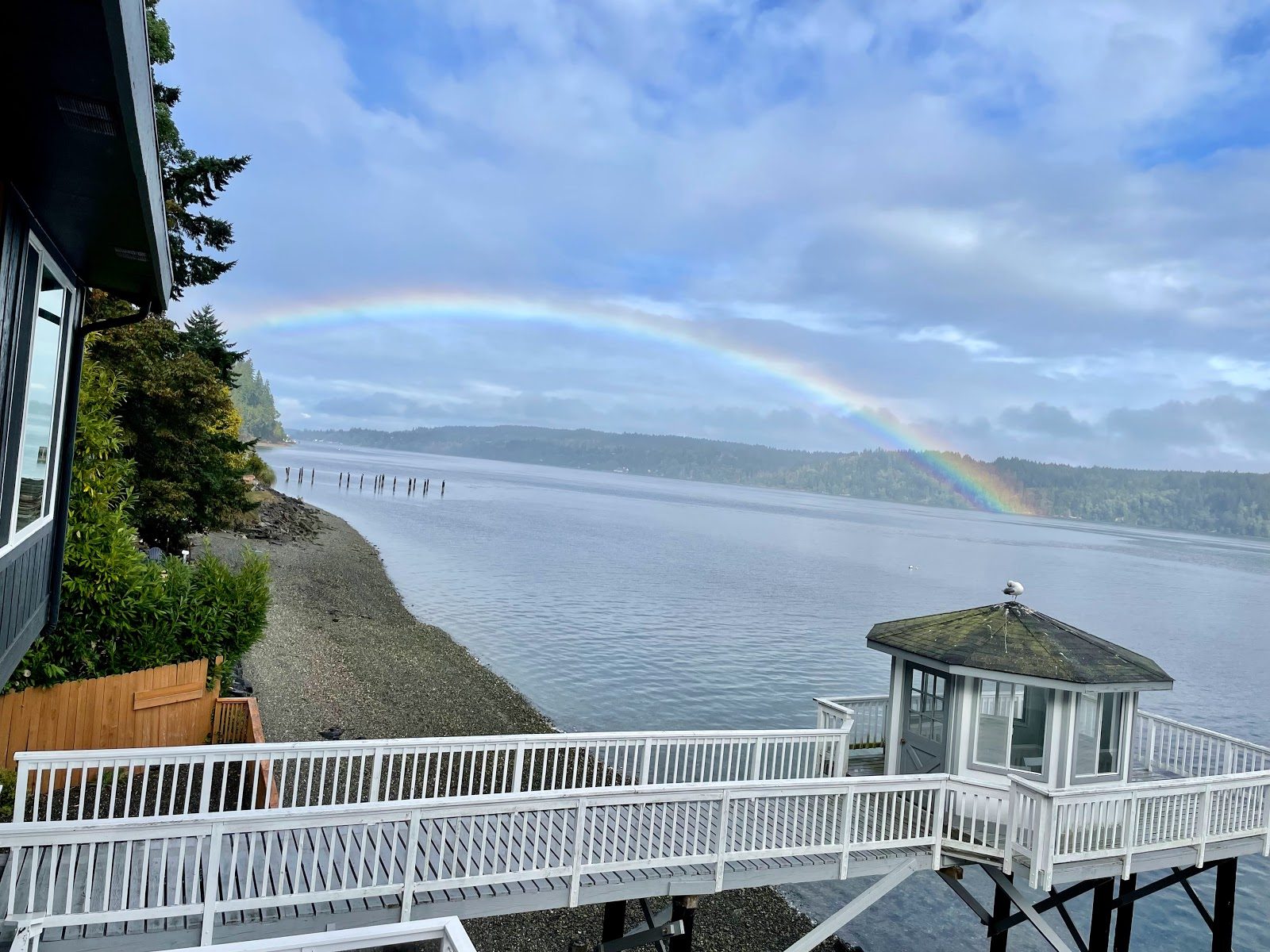A rainbow arcing over Olalla Bay, seen from the house, with the dock gazebo in the foreground