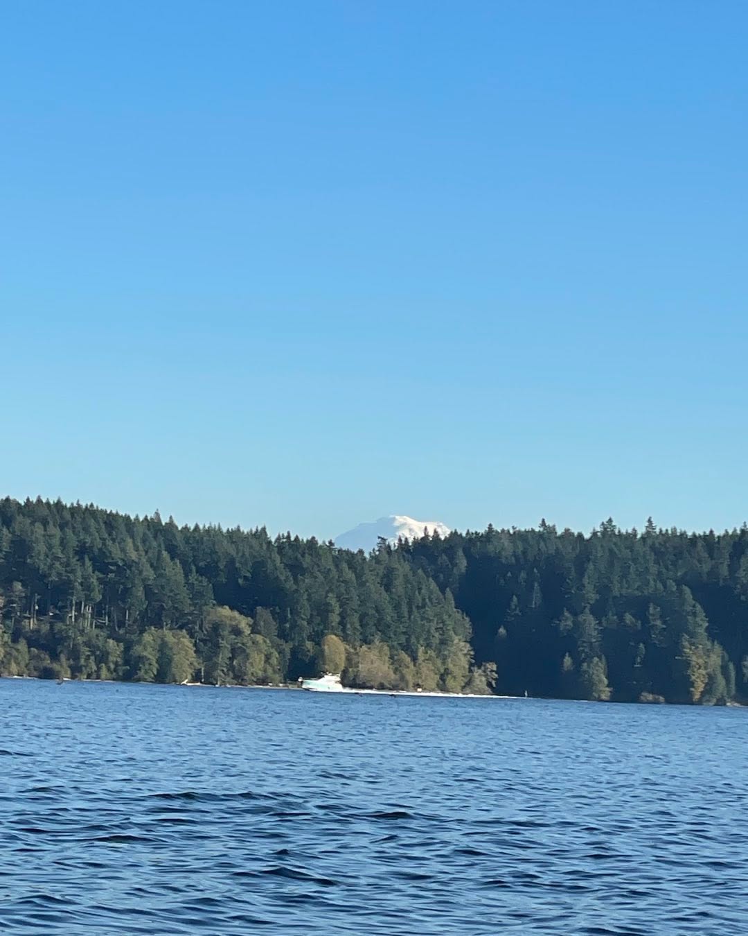 Mount Rainier rising behind Vashon Island across the water on a clear day