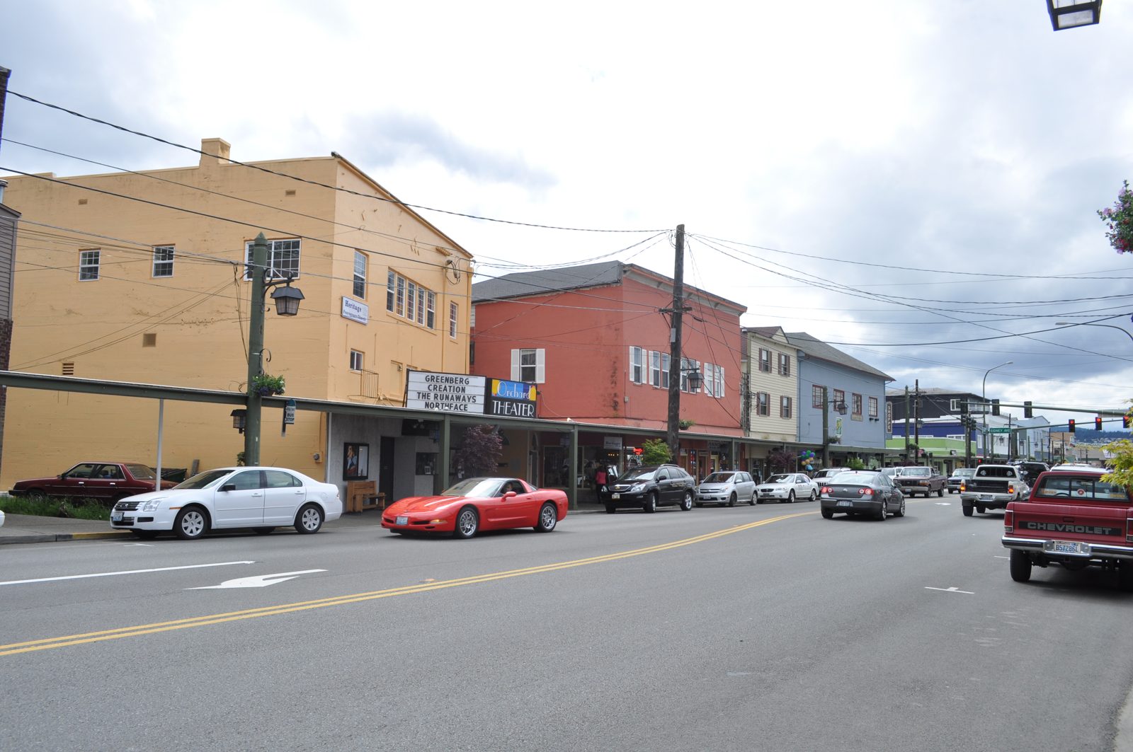 Bay Street in Port Orchard, with the Orchard Theater marquee, covered sidewalks, and colorful storefronts